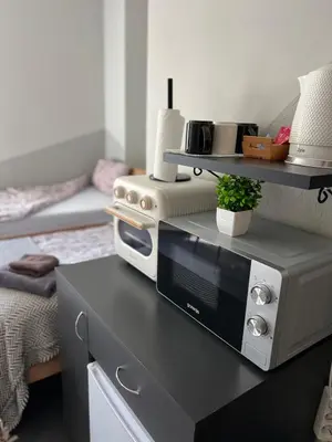 a kitchen with a microwave on a table at Šiauliu apartamentai in Šiauliai