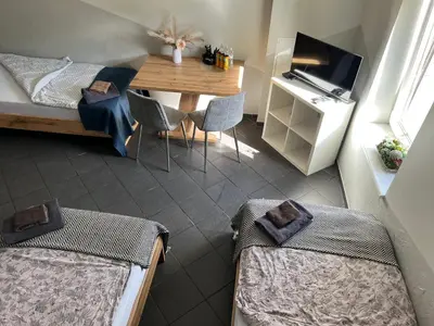 a room with a bed and a desk and a table at Šiauliu apartamentai in Šiauliai