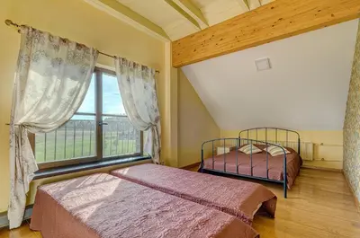 a bedroom with two beds and a large window at Spacious Villa with Large Hall in Mindūnai