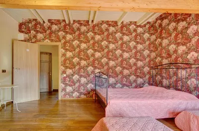 a bedroom with a floral patterned wall at Spacious Villa with Large Hall in Mindūnai