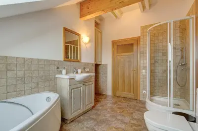 a bathroom with a tub and a sink and a toilet at Spacious Villa with Large Hall in Mindūnai