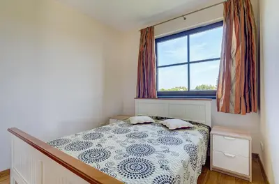 a small bedroom with a bed and a window at Spacious Villa with Large Hall in Mindūnai