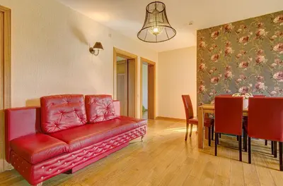 a living room with a red couch and a table at Spacious Villa with Large Hall in Mindūnai
