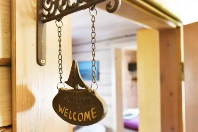 a sign that says welcome hanging from a chain at Vila Tauragnas in Varniškės I