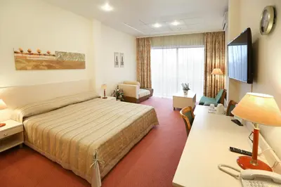 a hotel room with a bed and a desk with a computer at Smėlynė in Panevėžys