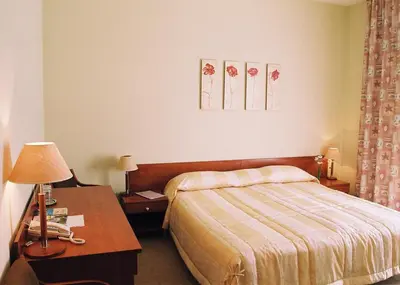 a hotel room with a bed and a table with a lamp at Smėlynė in Panevėžys