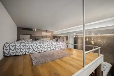 a bedroom with a large bed and a wooden floor at Secret Lounge - Cozy Studio with Sauna and Jacuzzi in Vilnius
