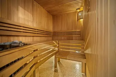 a wooden sauna with wooden benches in a room at Secret Lounge - Cozy Studio with Sauna and Jacuzzi in Vilnius