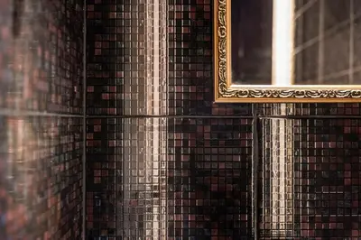a mirror with a gold frame on a brick wall at Secret Lounge - Cozy Studio with Sauna and Jacuzzi in Vilnius