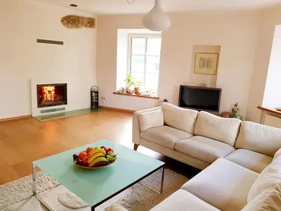 a living room with a bowl of fruit on a table at Exceptional Uzupis Bridge 3 bedroom apartment in Vilnius