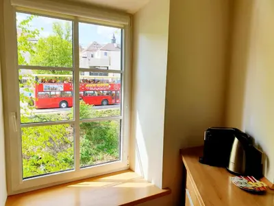 a window with a red double decker bus outside at Exceptional Uzupis Bridge 3 bedroom apartment in Vilnius
