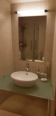 a bathroom with a large white sink and a mirror at Exceptional Uzupis Bridge 3 bedroom apartment in Vilnius