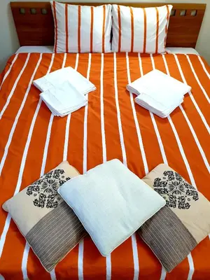 a bed with four towels and pillows on it at Exceptional Uzupis Bridge 3 bedroom apartment in Vilnius