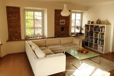 a living room with a couch and a glass table at Exceptional Uzupis Bridge 3 bedroom apartment in Vilnius