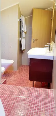 a bathroom with a white sink and a toilet at Exceptional Uzupis Bridge 3 bedroom apartment in Vilnius
