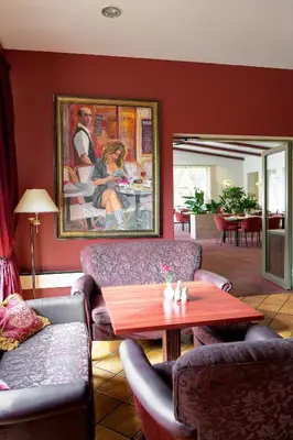 a living room with couches and a table and a painting at Regina in Druskininkai
