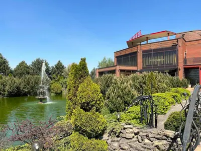 a building with a fountain in the middle of a pond at Via Baltica in Sargėnai