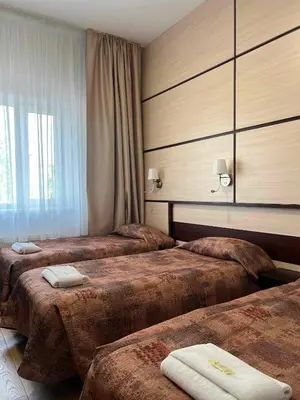 a hotel room with three beds with towels on them at Via Baltica in Sargėnai
