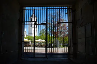 an open gate with a view of a building behind it at Cathedral Sq. Apartment - Odminiu Str. in Vilnius