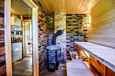 a room with a brick wall and a wood stove at Mekų slėnis in Degučiai