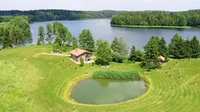 an aerial view of a house on a hill next to a lake at Mekų slėnis in Degučiai