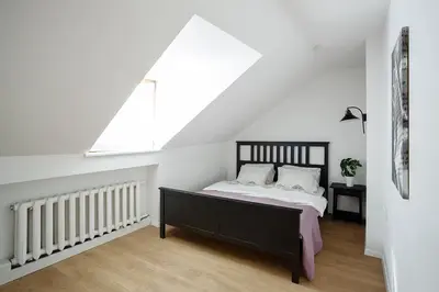 a bedroom with a bed and a window at Baron's Arthouse Apartment in Vilnius