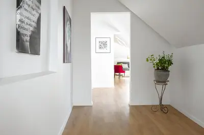 a hallway with a potted plant on a stand at Baron's Arthouse Apartment in Vilnius