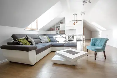 a living room with a couch and a chair at Baron's Arthouse Apartment in Vilnius