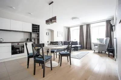 a kitchen and living room with a table and chairs at Baron's Town Hall Apartments in Vilnius
