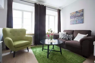 a living room with a couch and a table and a chair at Baron's Town Hall Apartments in Vilnius