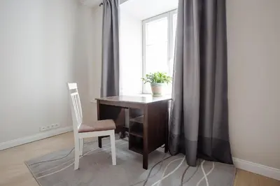 a desk and chair in a room with a window at Baron's Town Hall Apartments in Vilnius