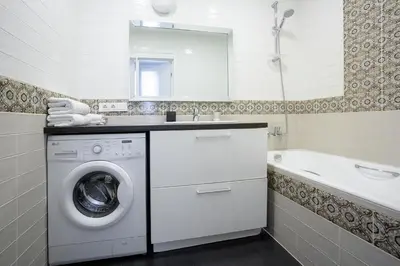 a white bathroom with a washing machine and a tub at Baron's Town Hall Apartments in Vilnius