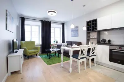 a kitchen and living room with a table and chairs at Baron's Town Hall Apartments in Vilnius