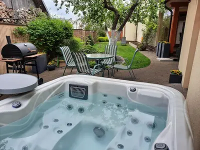 a hot tub in a backyard with a table and chairs at Rest ART in Anykščiai