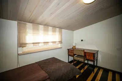 a bedroom with a bed and a desk and a window at Rest ART in Anykščiai