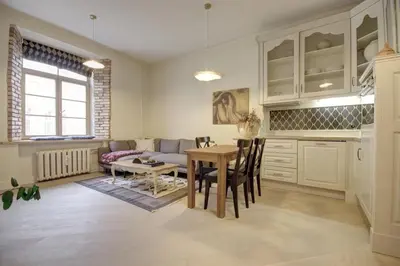a kitchen and living room with a table and a couch at Town Hall Square Apartments in Vilnius
