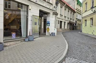 an empty street in a city with buildings at Town Hall Square Apartments in Vilnius