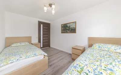 two beds in a bedroom with white walls at Prie Lukos ezero in Trakai