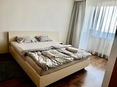 a bed with blankets and pillows on it in a bedroom at Apartamentai in Marijampolė