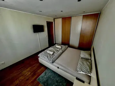 a small bedroom with a bed and a television at Apartamentai in Marijampolė