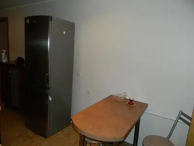a kitchen with a black refrigerator and a wooden table at Apartamentai in Marijampolė