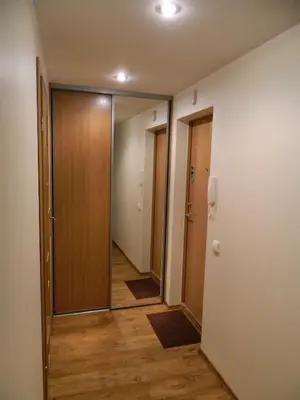 an empty hallway with a door and a mirror at Apartamentai in Marijampolė