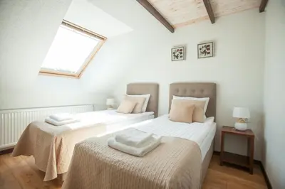 two twin beds in a room with a window at Central Hotel Radviliškis in Radviliškis