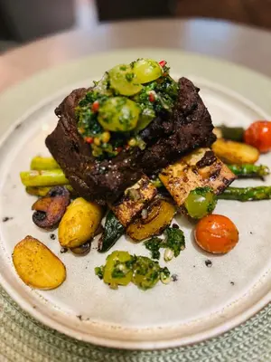 a plate of food with meat and vegetables on it at Central Hotel Radviliškis in Radviliškis