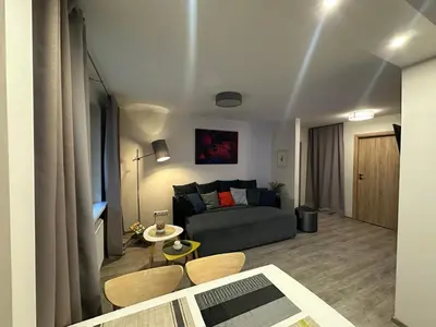 a living room with a couch and a table at Smiltės apartamentai in Birštonas