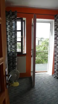 an orange room with an open door with a window at Apartment 5A in Kaunas