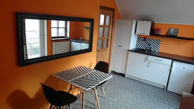 a small kitchen with a table and a mirror at Apartment 5A in Kaunas
