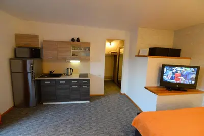 a kitchen with a refrigerator and a television in a room at Apartment 5A in Kaunas