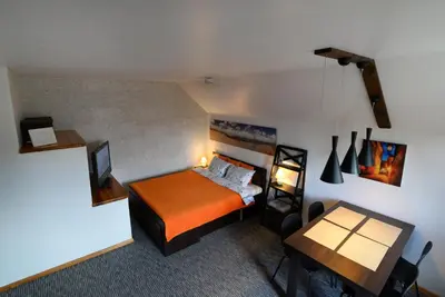 a bedroom with a bed and a desk and a table at Apartment 5A in Kaunas