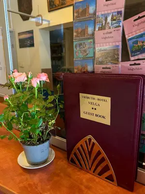 a sign on a table with a potted plant at Velga in Vilnius